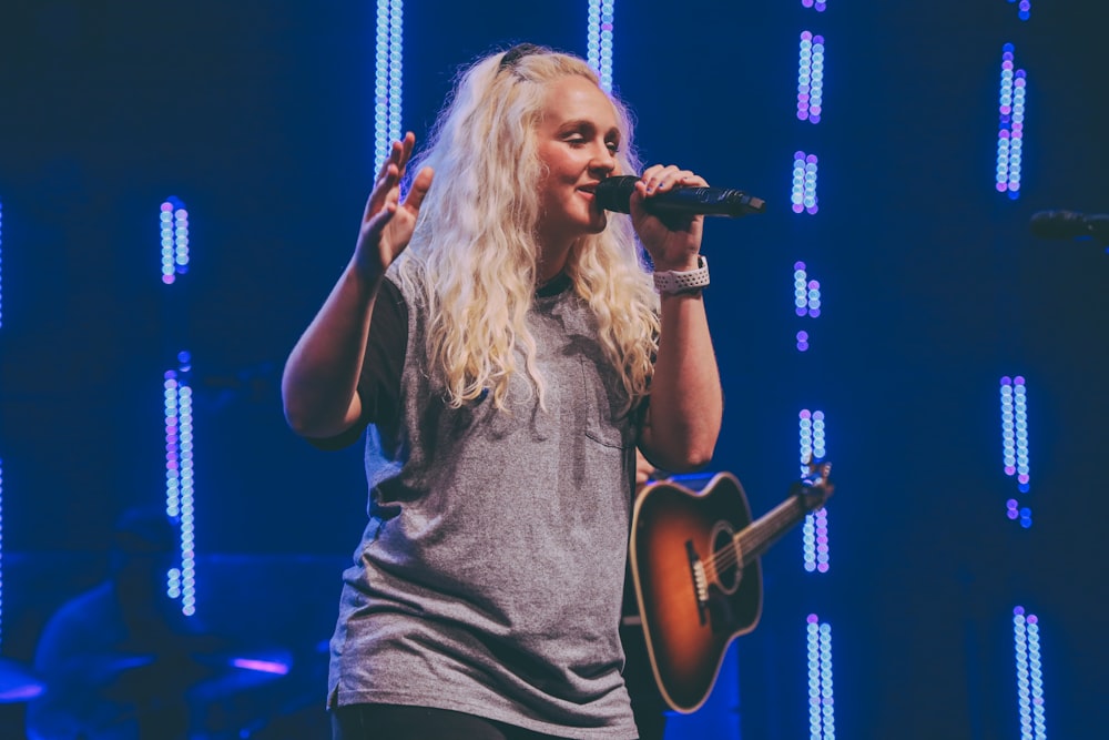 woman in gray sleeveless shirt singing