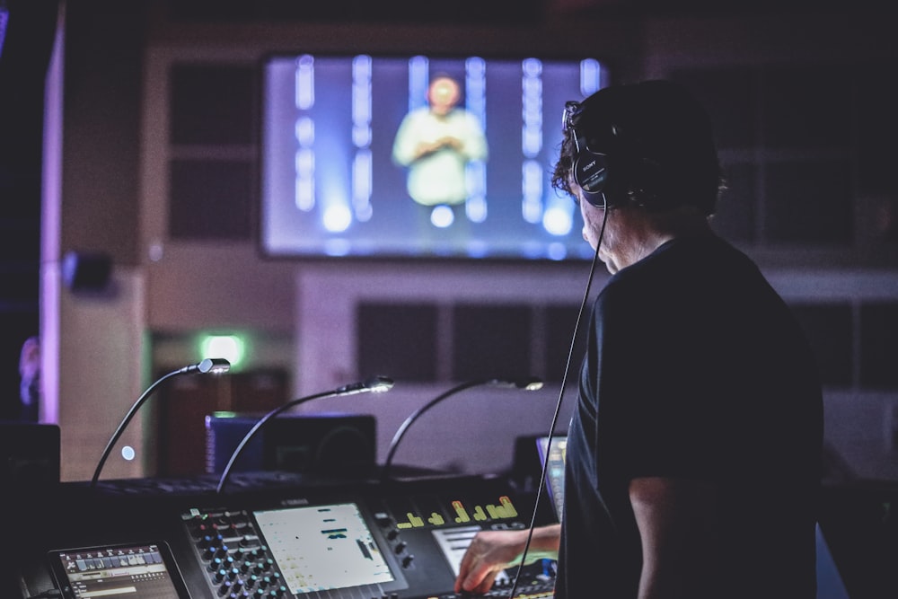 woman in black shirt standing in front of audio mixer