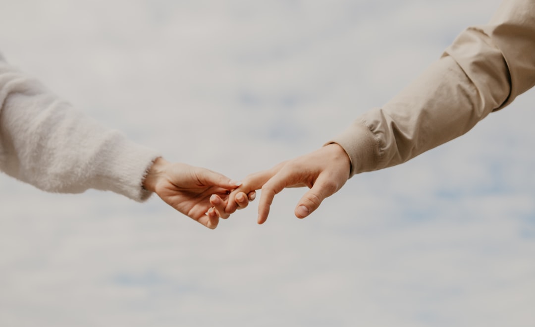 person in white long sleeve shirt holding hands with woman in white long sleeve shirt during