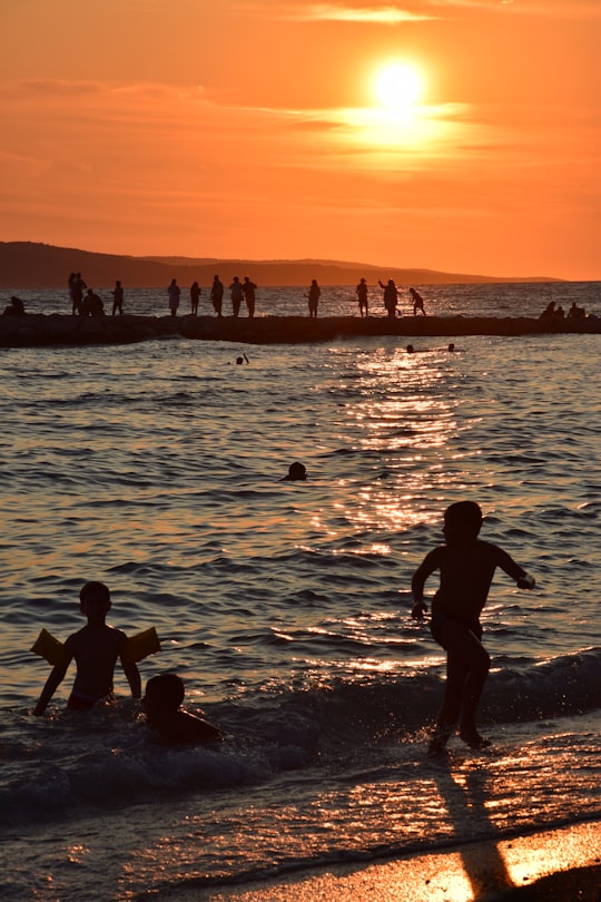 silhouette of people on beach during sunset in Makarska Croatia