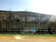 A panoramic view of various fence styles in a sunny landscape.