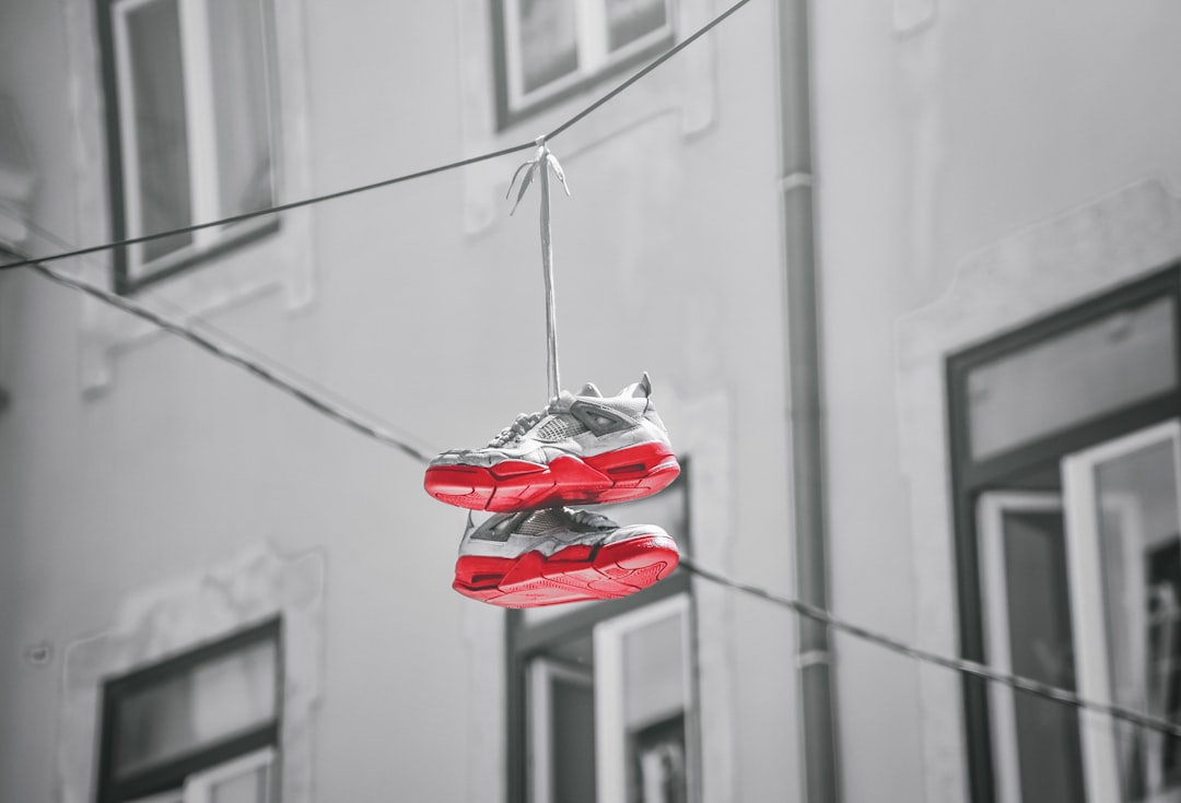 red and white sneakers hanging on wire