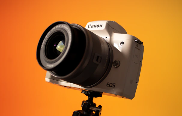 Close-up shot of a sleek DSLR camera with a vibrant outdoor background.
