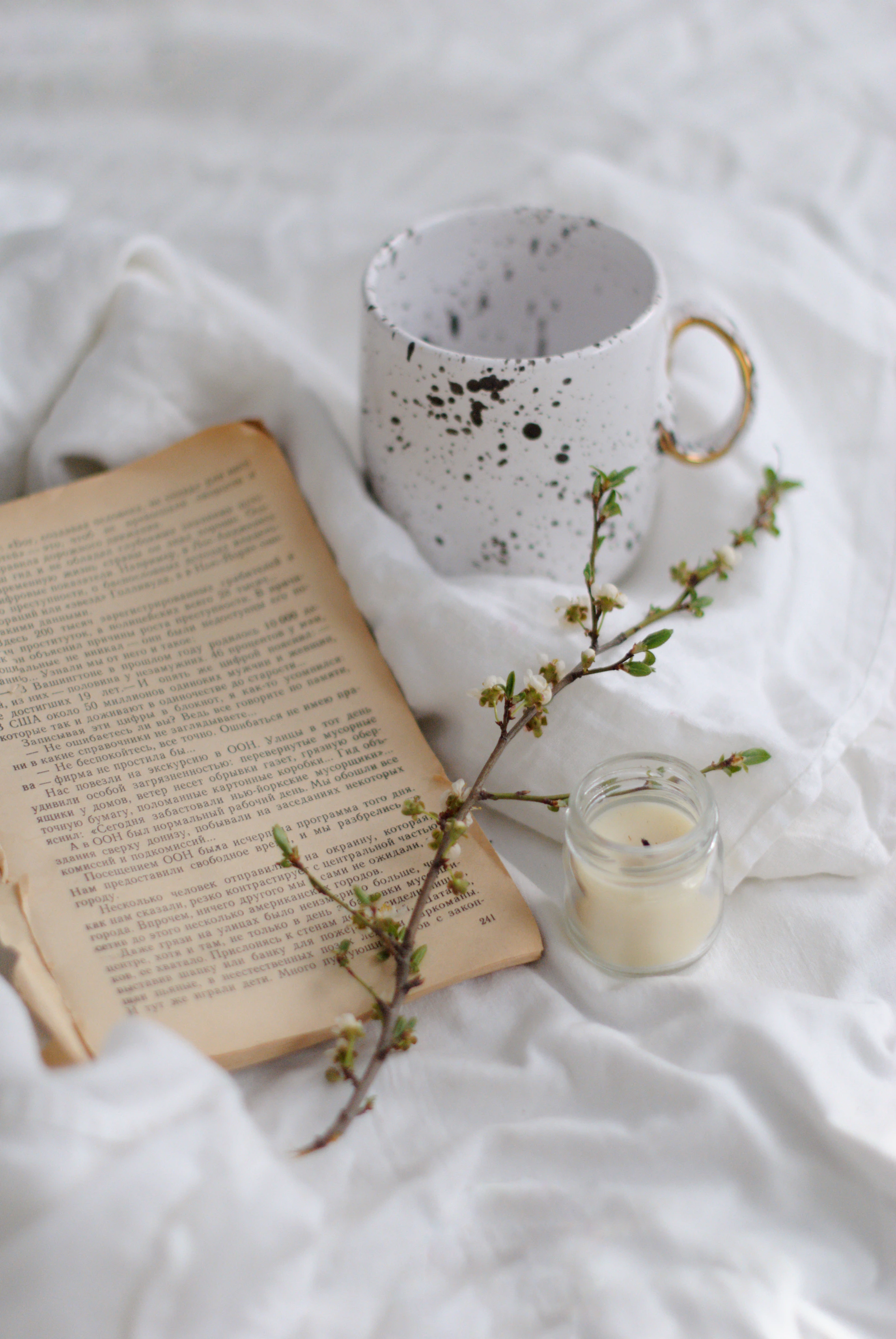 white ceramic mug on white textile