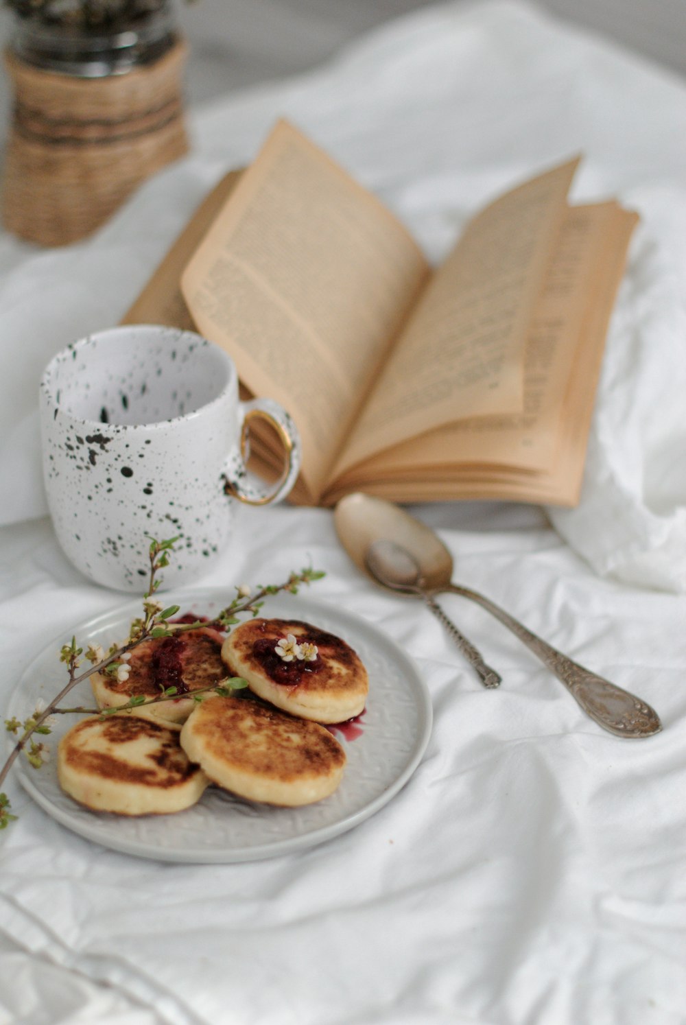 white ceramic mug beside stainless steel spoon on white ceramic plate