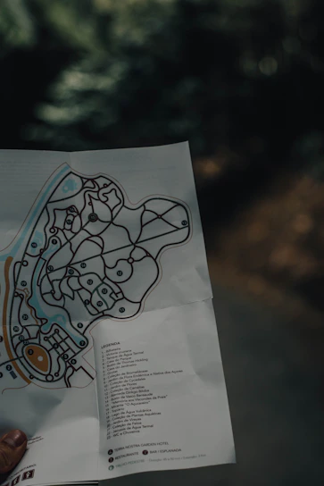 Close-up of a traveler’s hands holding a digital tablet displaying a detailed itinerary map with highlighted routes.