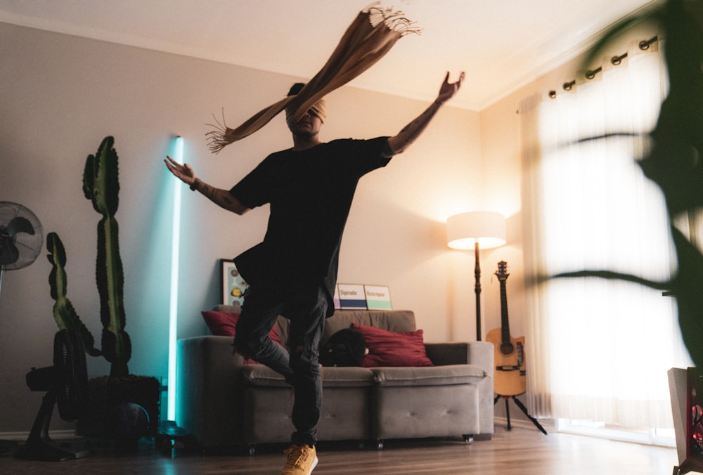 woman in black long sleeve shirt and black pants standing on brown wooden floor