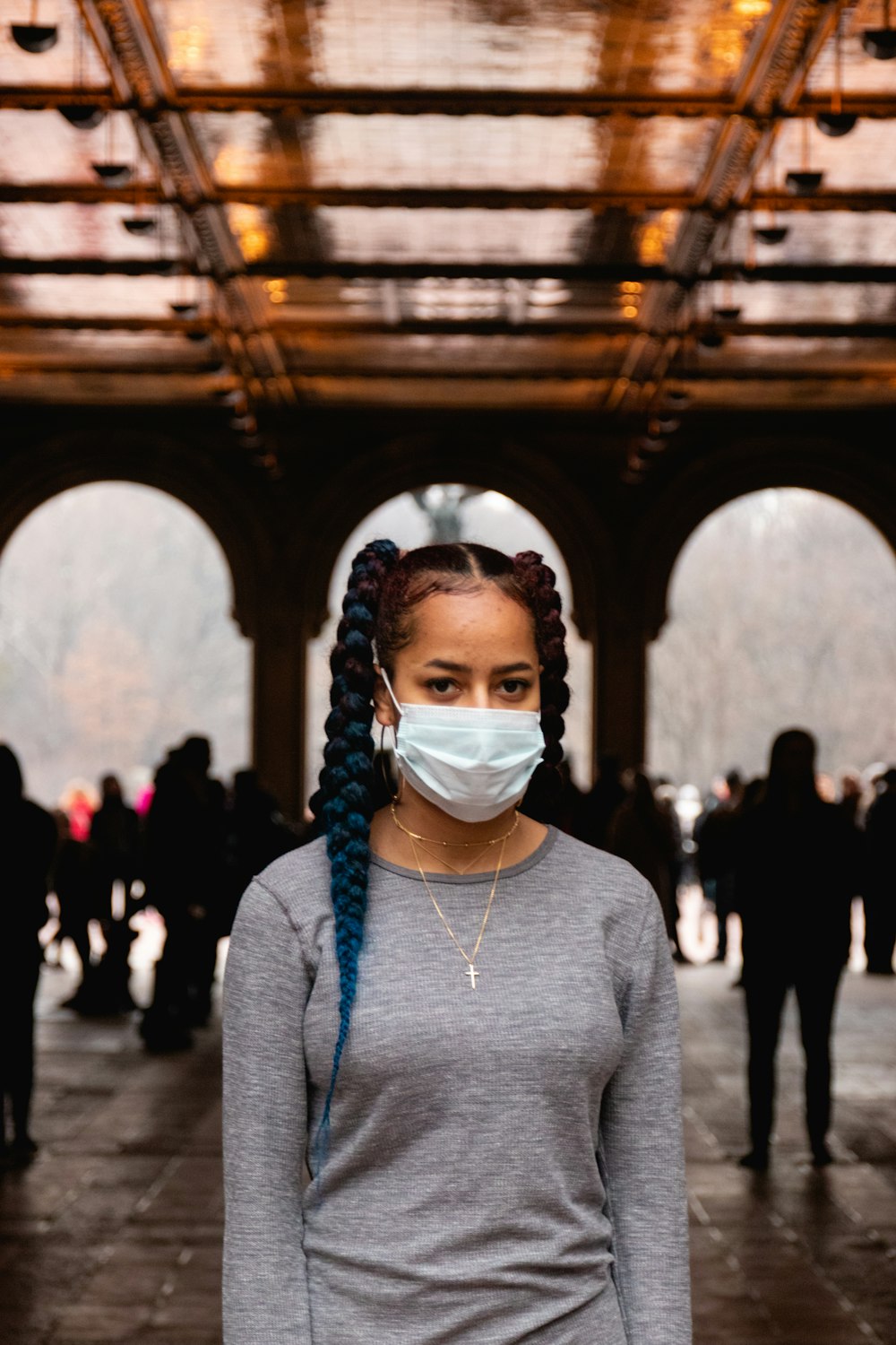 woman in gray turtleneck sweater wearing white mask