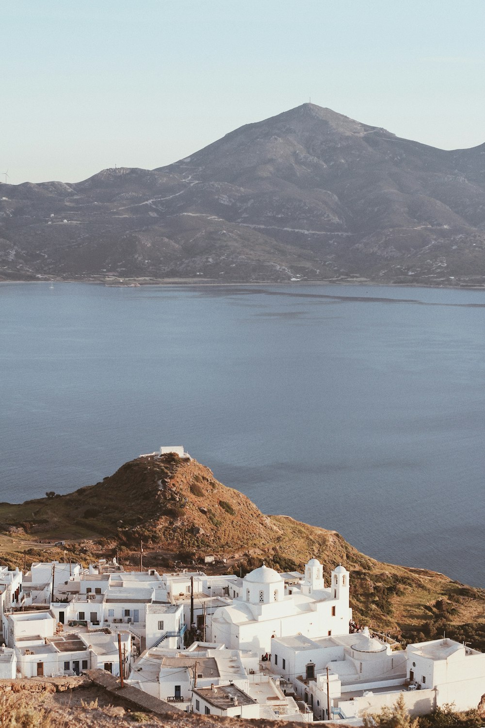 white houses near body of water and mountain during daytime