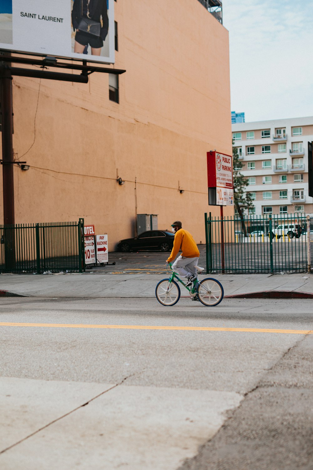 man in yellow shirt riding bicycle on road during daytime
