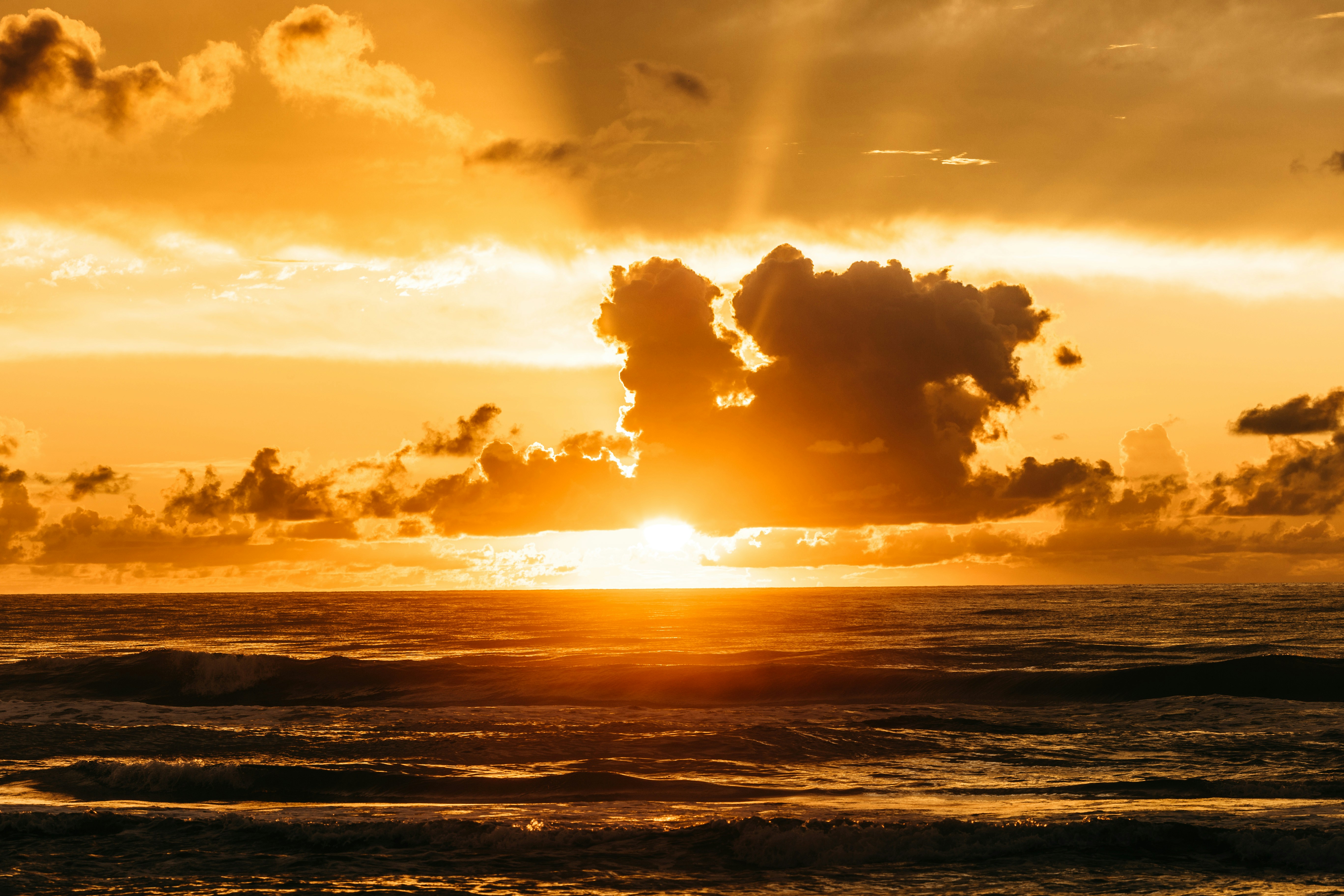 sea waves crashing on shore during sunset