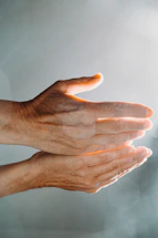 A serene image of hands gently glowing with healing energy under soft light.