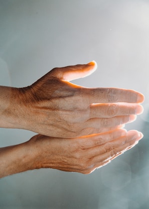 persons hand with white nail polish