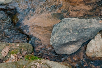A tranquil scene of a flowing river with smooth stones and gentle ripples.
