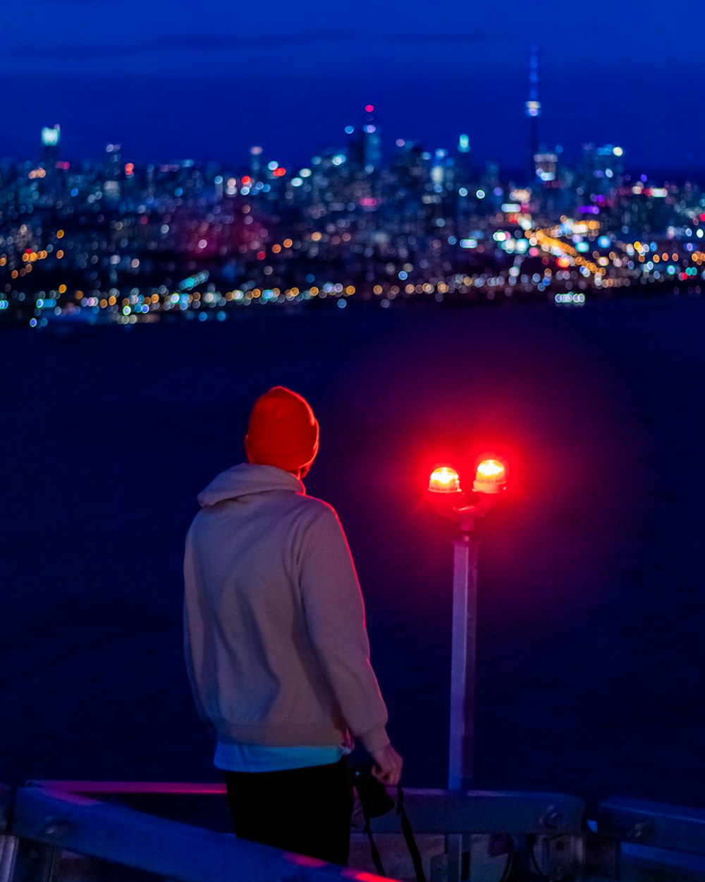 man in white hoodie standing on top of building during night time