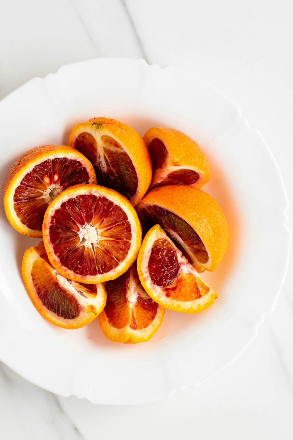 흰색 세라믹 접시에 얇게 썬 오렌지 과일