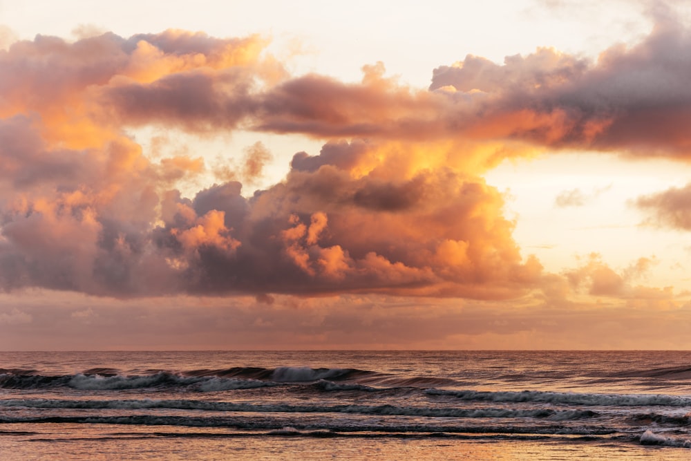 sea waves crashing on shore during sunset