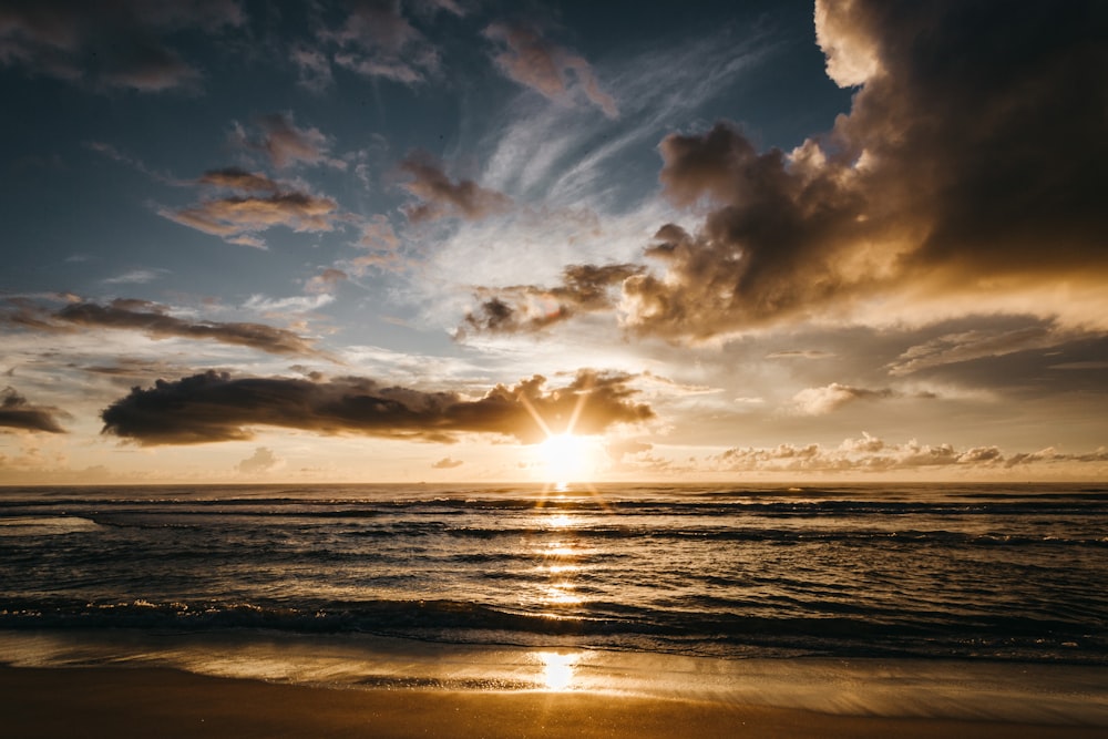 Gewässer unter bewölktem Himmel bei Sonnenuntergang