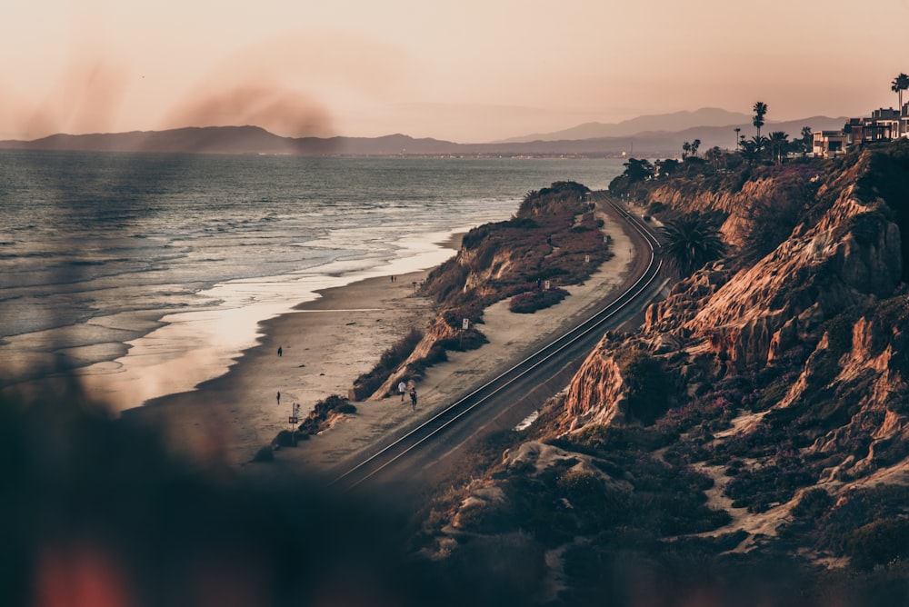 aerial view of road near body of water during sunset