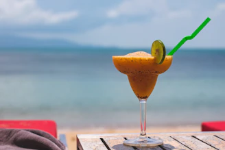 Tropical drink served with colorful straws and fresh flowers on a sunny patio