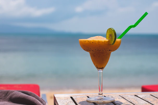 Tropical drink served with colorful straws and fresh flowers on a sunny patio