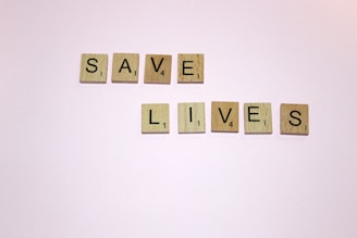 scrabble letters spelling save lives on a white background