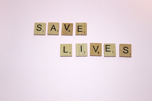 scrabble letters spelling save lives on a white background