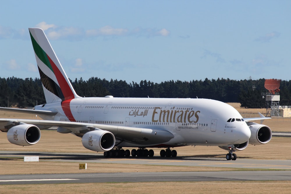 white and red passenger plane on airport during daytime