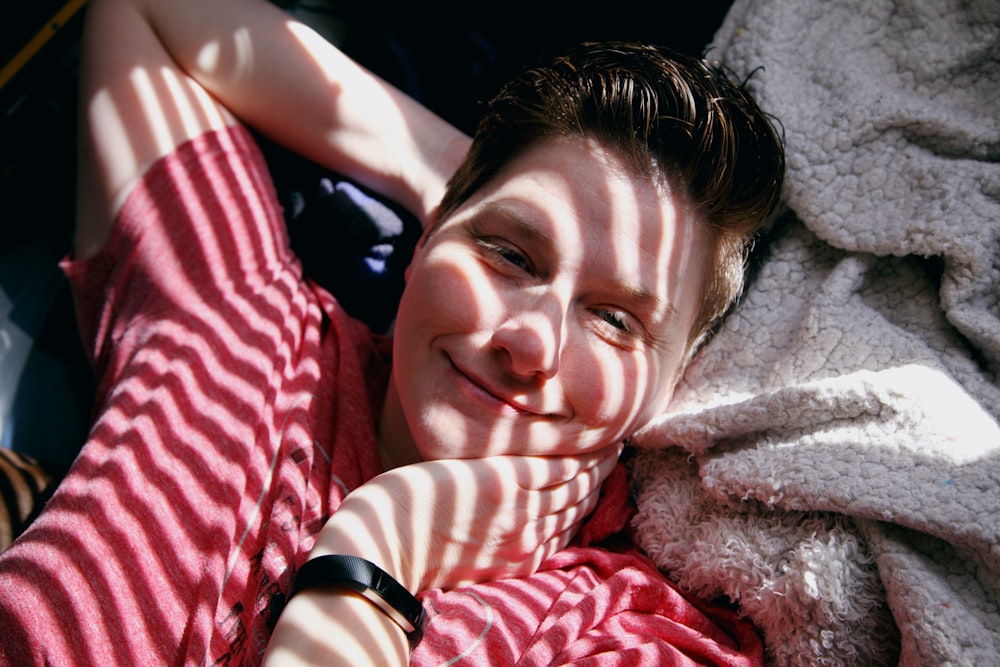 woman in red and white stripe shirt lying on bed