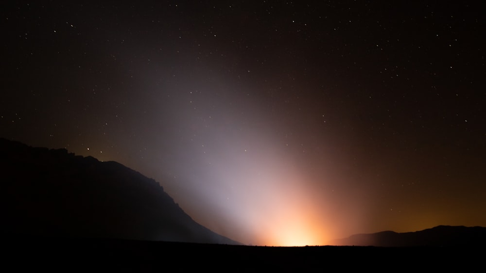 silhouette of mountain during night time