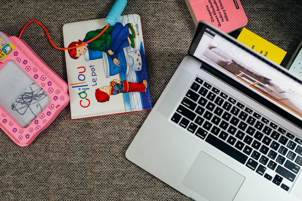 macbook pro beside white and pink book