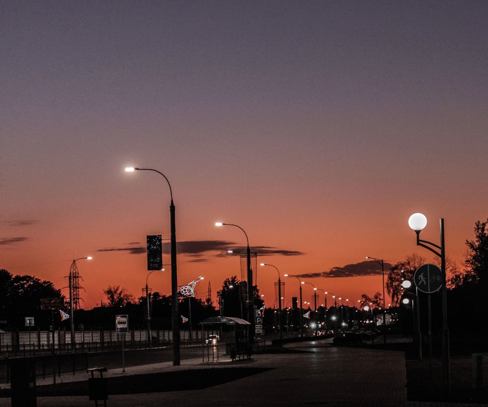 people walking on sidewalk during sunset