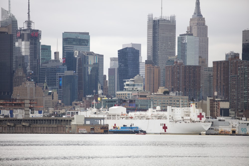 white ship on body of water near city buildings during daytime