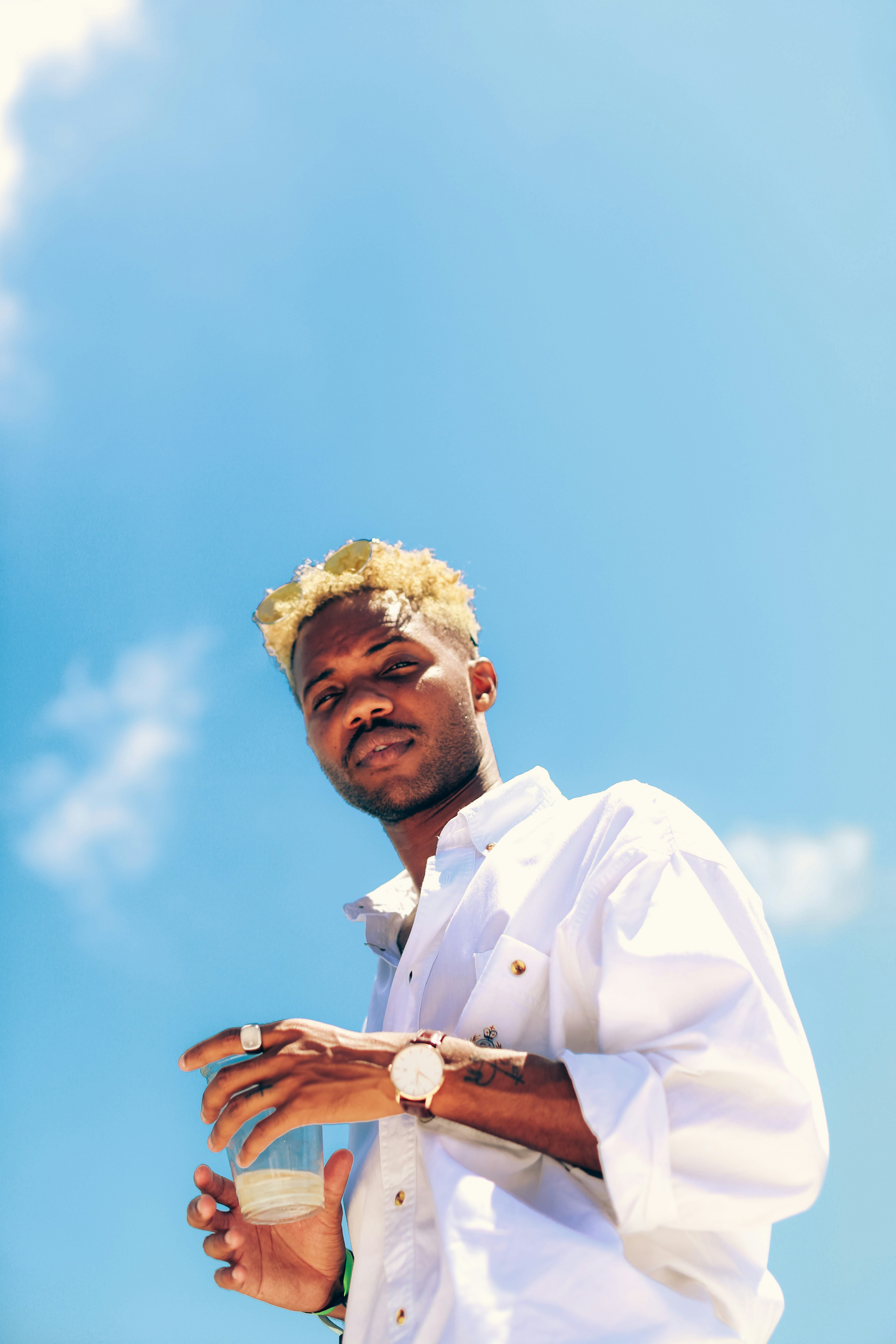 man in white dress shirt with yellow flower on head