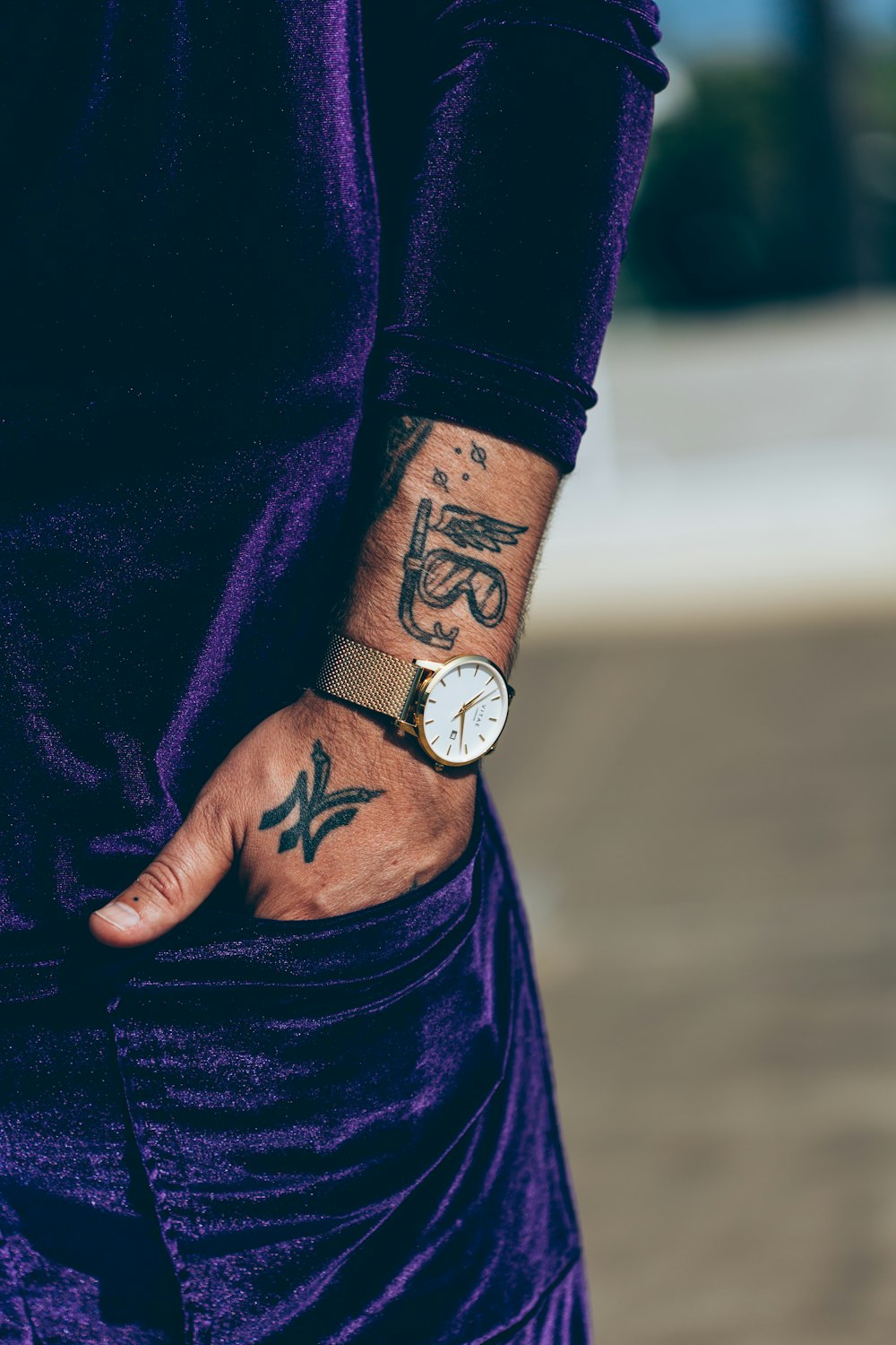 person in purple long sleeve shirt wearing silver round analog watch
