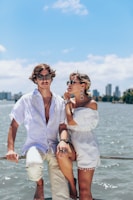 A stylish man and woman enjoying a sunset on a luxury yacht deck.