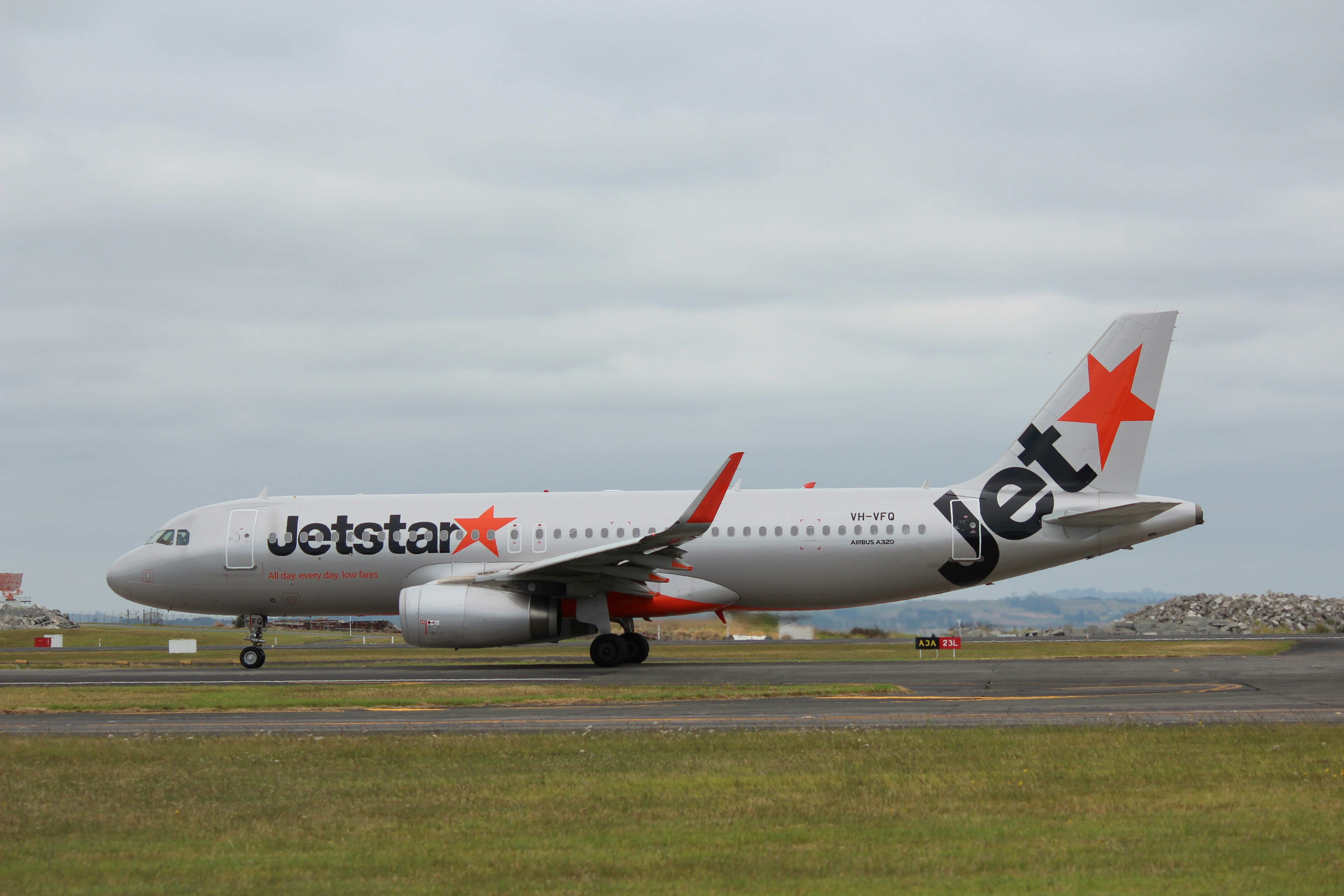 white and red passenger plane on airport during daytime, Jetstar A320-200 (VH-VFQ) taxis at Auckland