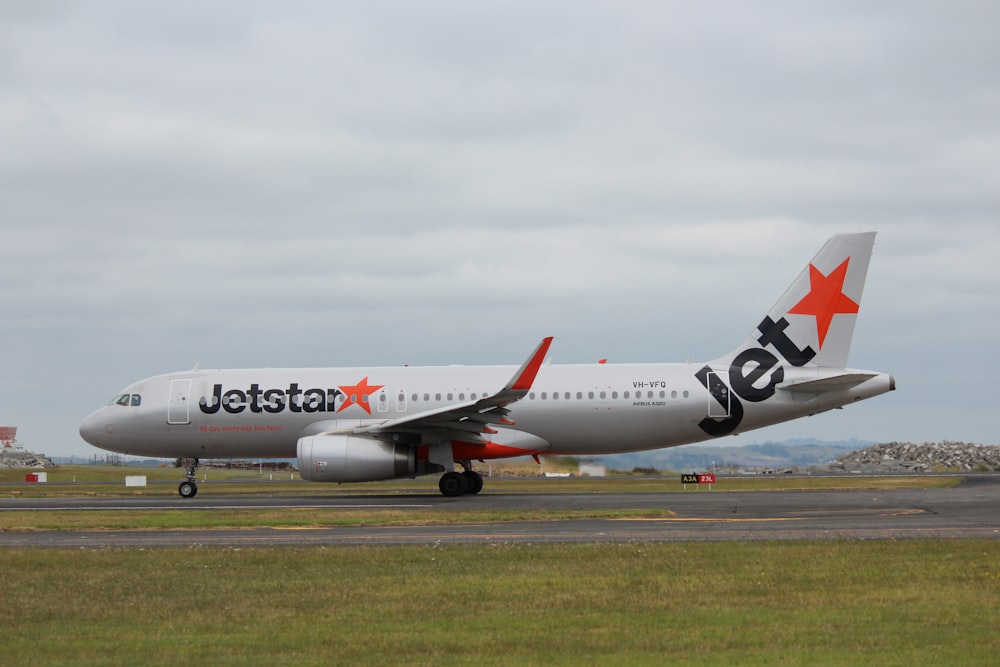 white and red passenger plane on airport during daytime