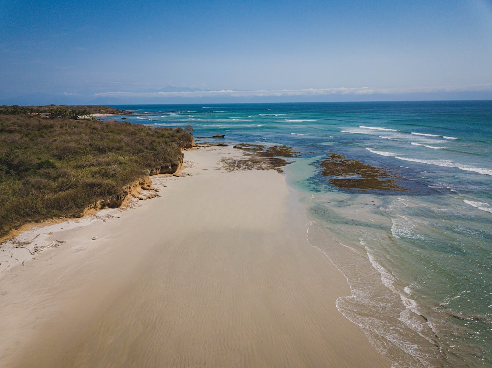 praia de areia marrom durante o dia