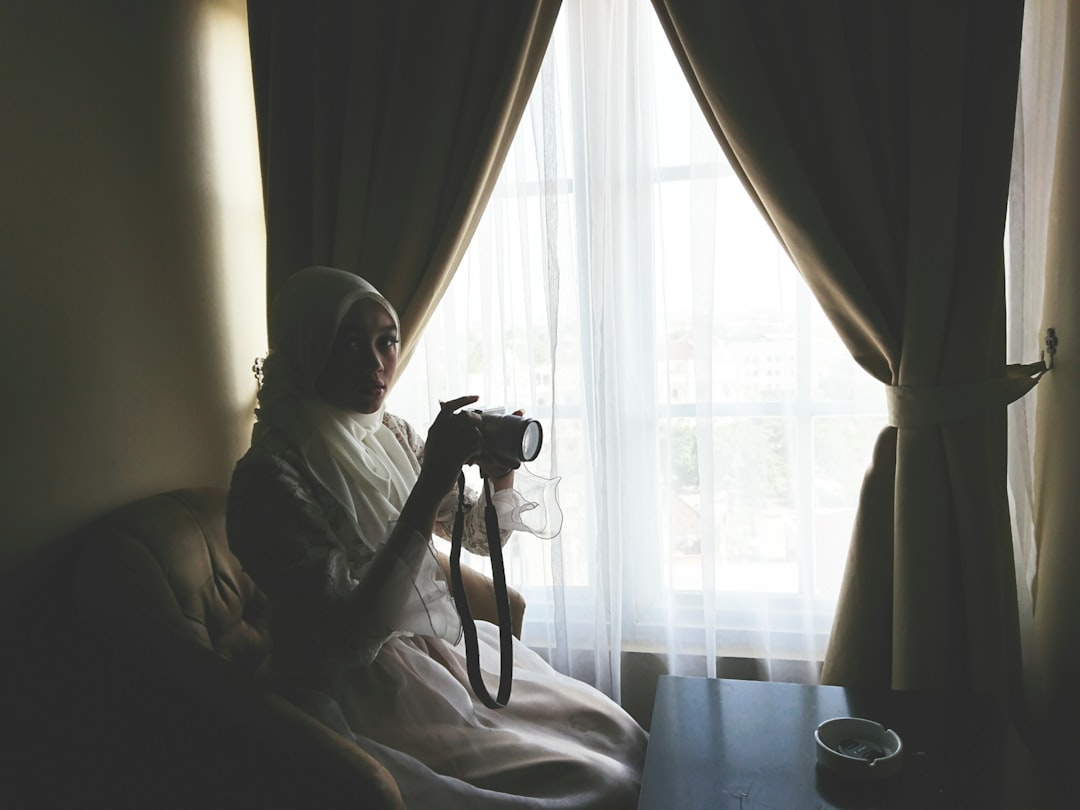 man in gray hoodie sitting on bed,