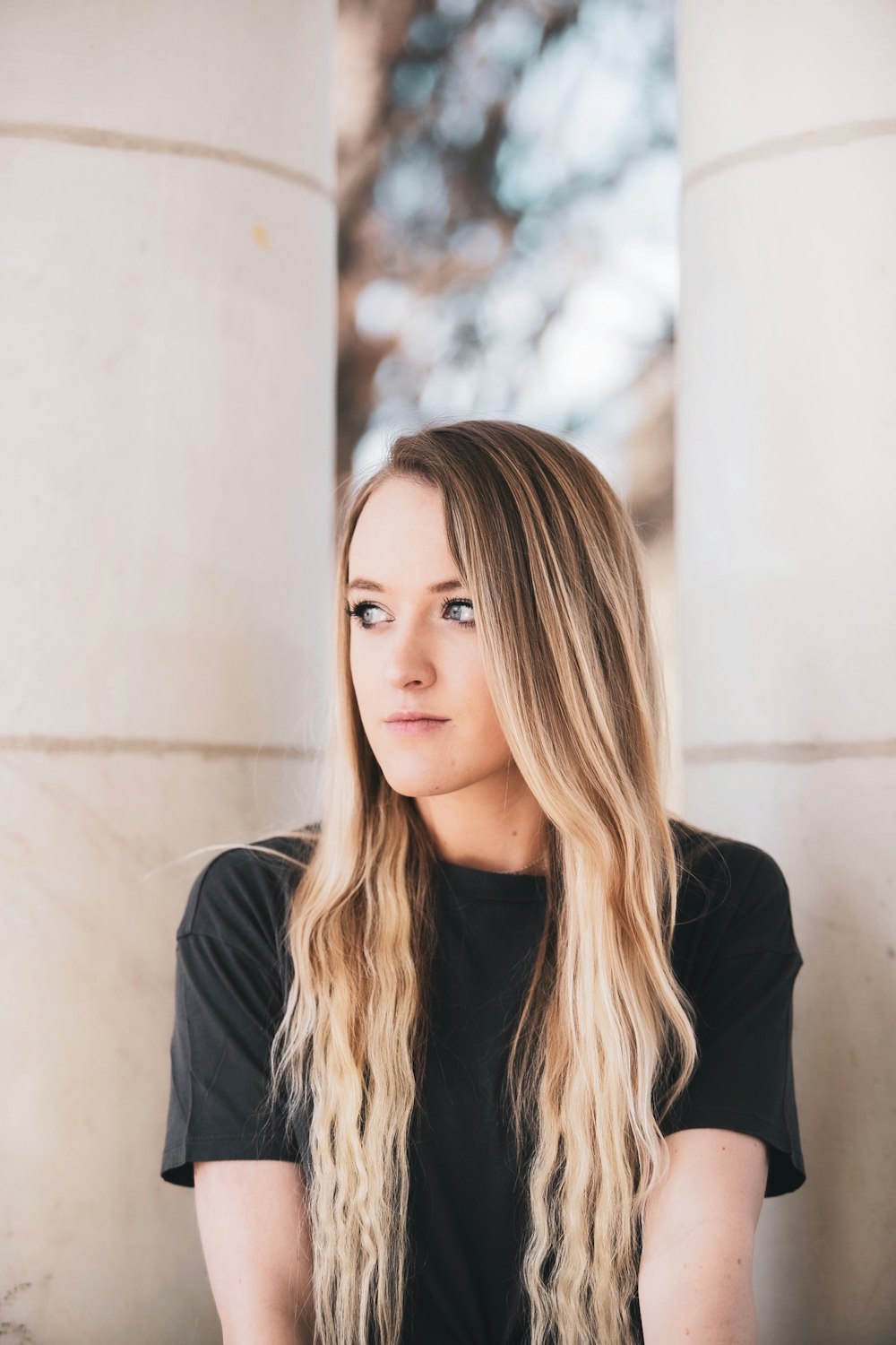 woman in black blazer standing near white wall