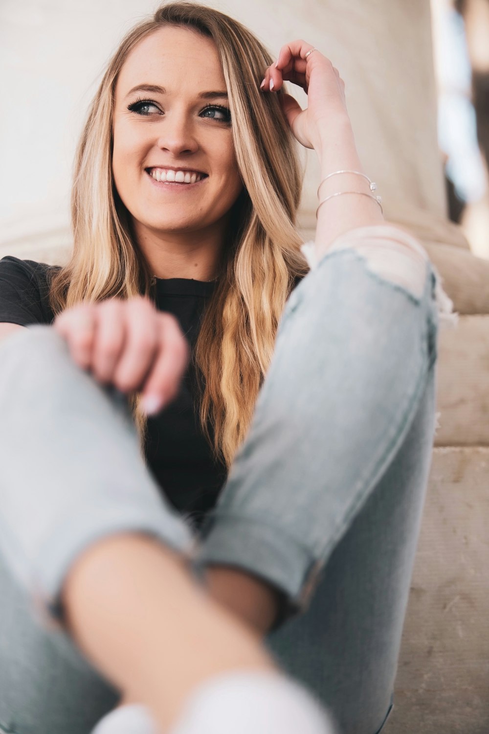 woman in white long sleeve shirt and blue denim jeans smiling