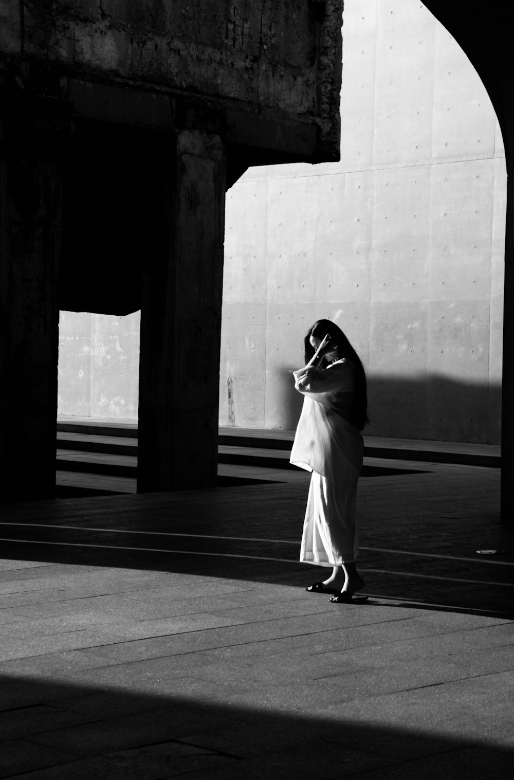 femme en robe blanche debout sur le sol noir