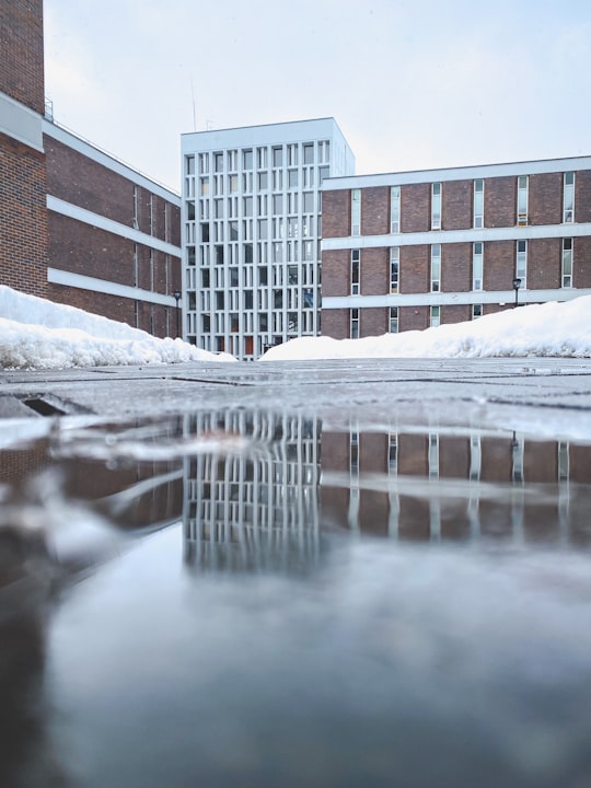 snow covered road near brown concrete building during daytime in Carleton University Canada