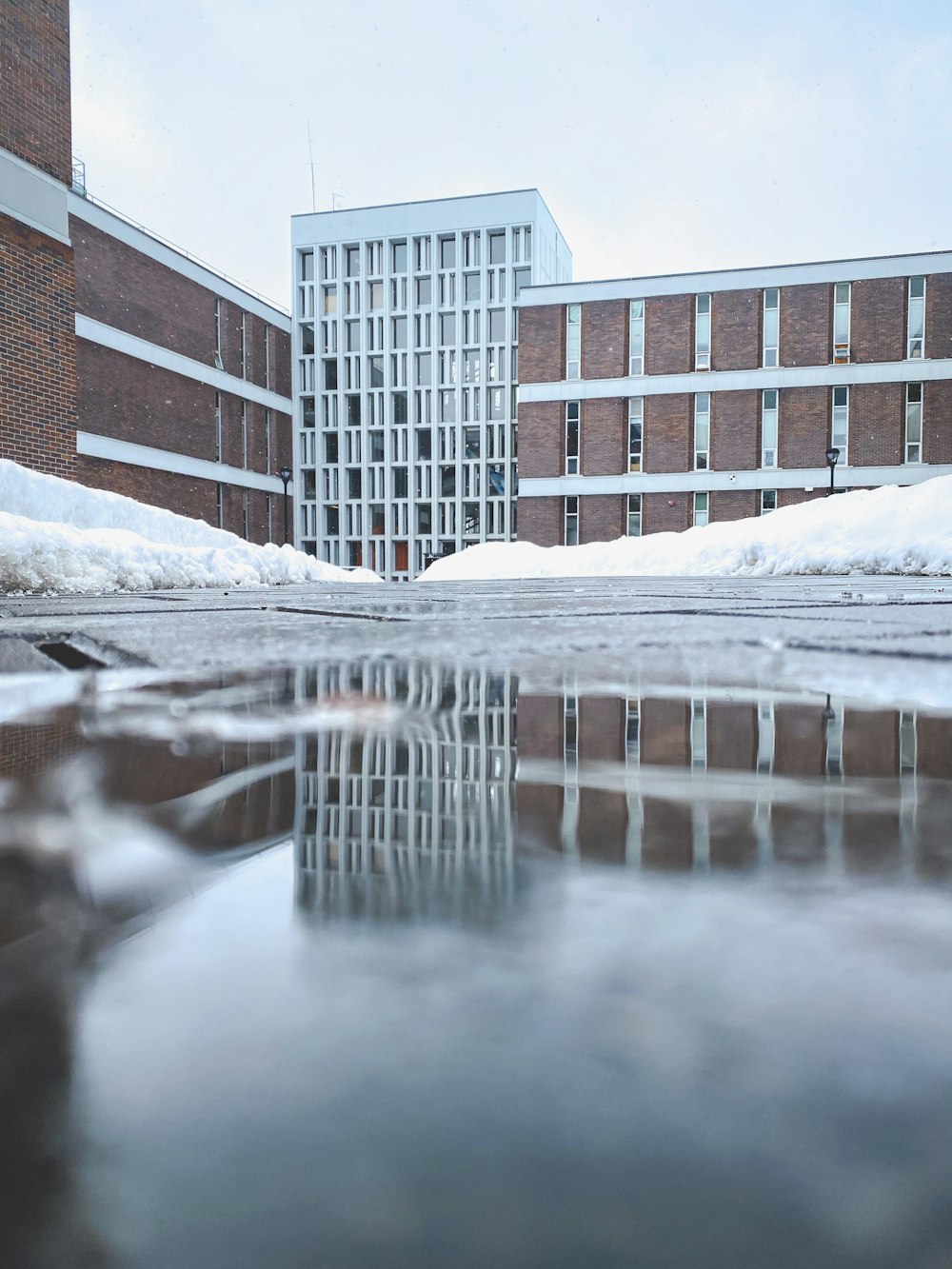 snow covered road near brown concrete building during daytime