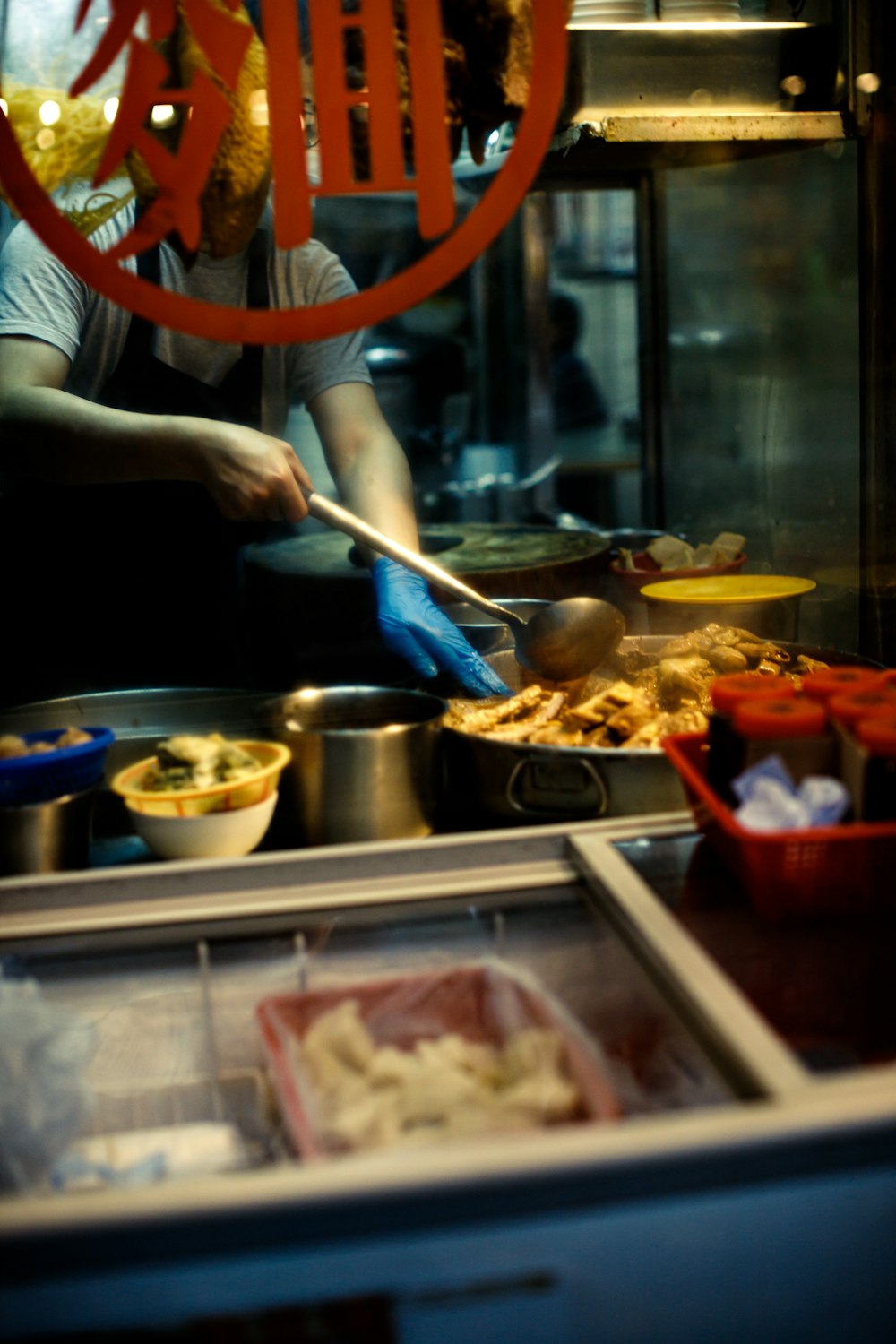 person in white apron holding brown wooden chopsticks