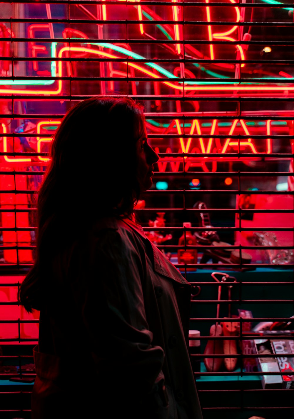 woman in brown jacket standing in front of red metal rack