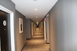 hallway with white walls and ceiling light turned on in room