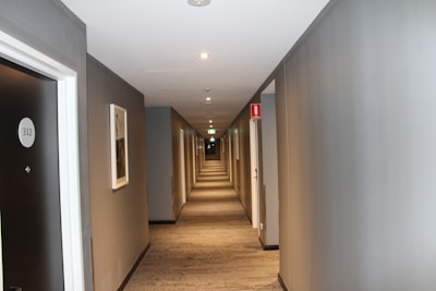 hallway with white walls and ceiling light turned on in room