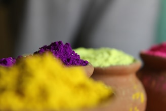 Colorful clay sweet containers arranged neatly with subtle Indian patterns in the background.